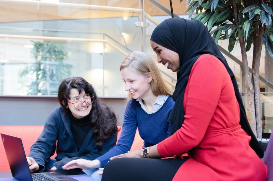 Kolme naista istuu tietokoneen äärelllä tekemässä töitä.